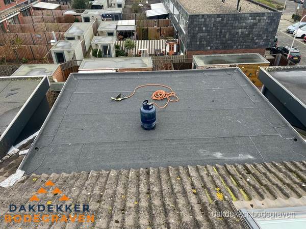 Plat dak met bitumen dakbedekking en brander in Bodegraven
