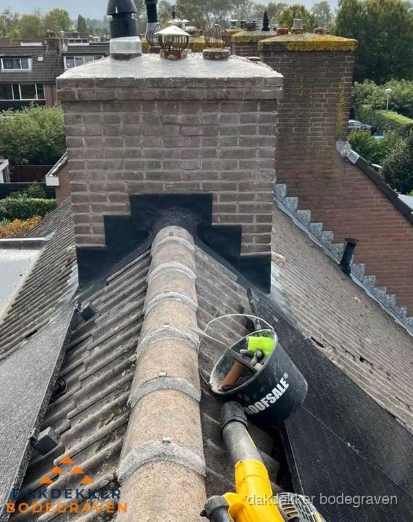 Schoorsteen met loodaansluiting en nokvorst op pannendak in Bodegraven Schoorsteen met loodaansluiting en nokvorst op pannendak in Bodegraven