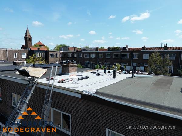 Dakdekkers aan het werk op plat dak in Bodegraven