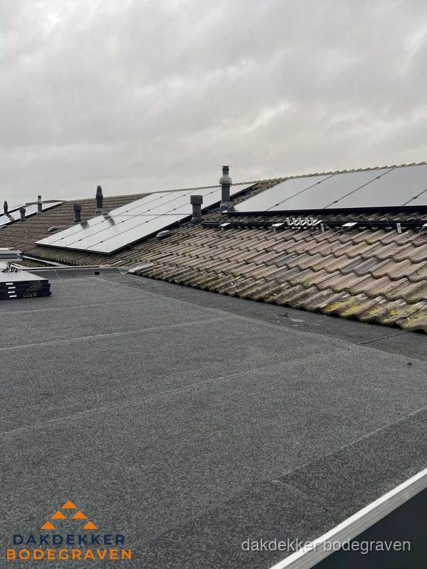 Bitumen dakbedekking op plat dak met aansluitend pannendak en zonnepanelen in Bodegraven