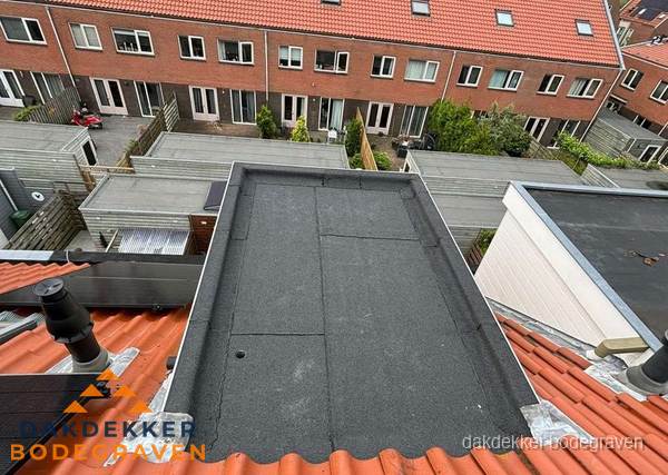 Plat dak met bitumen bedekking naast dakkapel in Bodegraven
