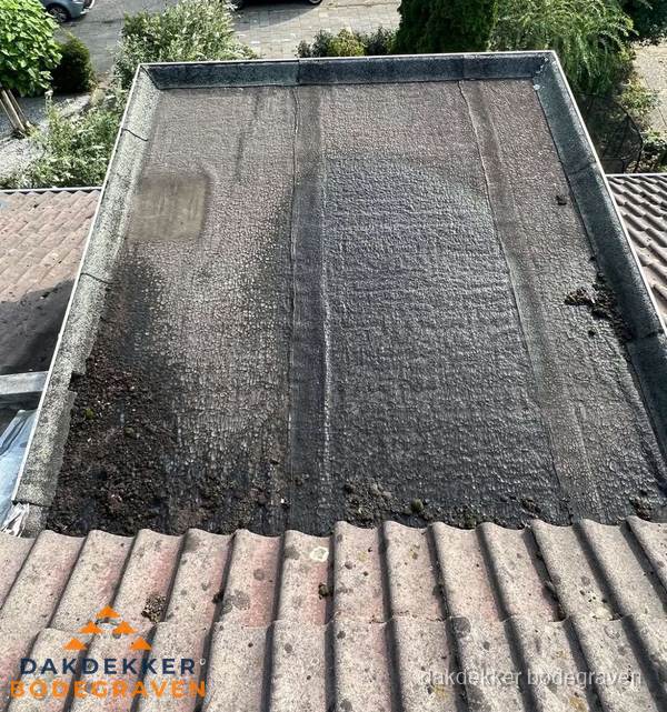 Verouderd plat dak met bitumen en slijtage voor lekkage inspectie in Bodegraven Verouderd plat dak met bitumen en slijtage voor lekkage inspectie in Bodegraven