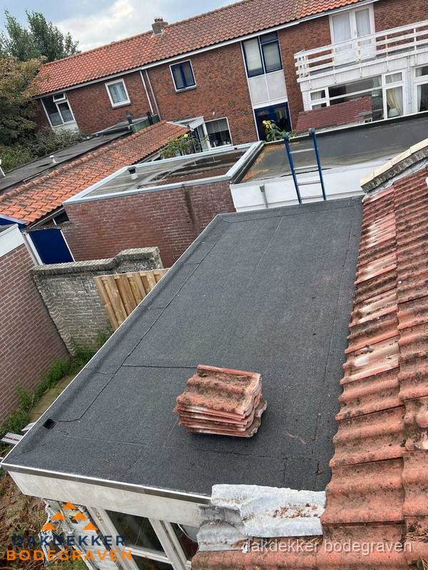 Plat dak aanbouw met bitumen naast schuin pannendak in Bodegraven Plat dak aanbouw met bitumen naast schuin pannendak in Bodegraven