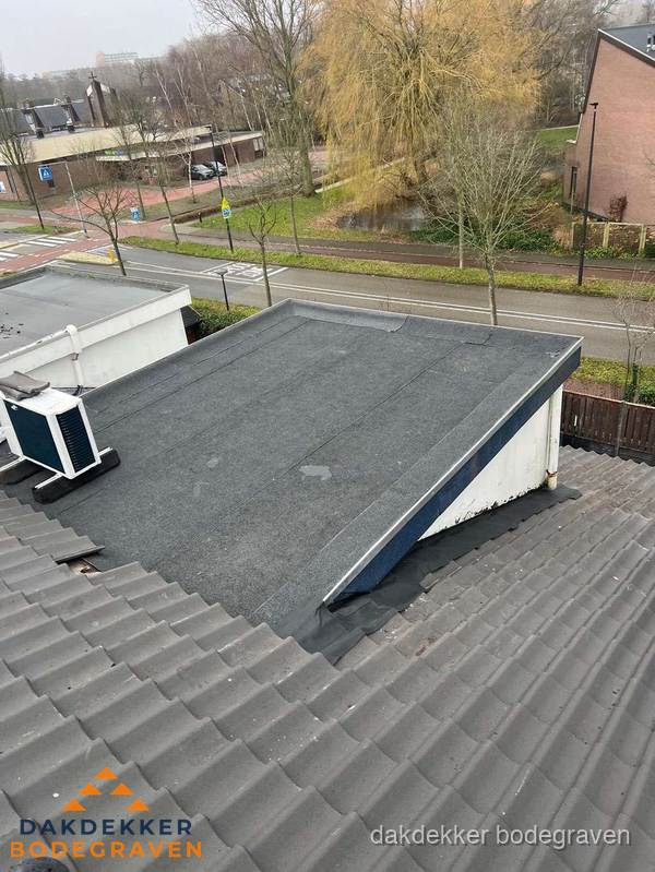 Plat dak met bitumen dakbedekking naast schuin pannendak in Bodegraven Plat dak met bitumen dakbedekking naast schuin pannendak in Bodegraven