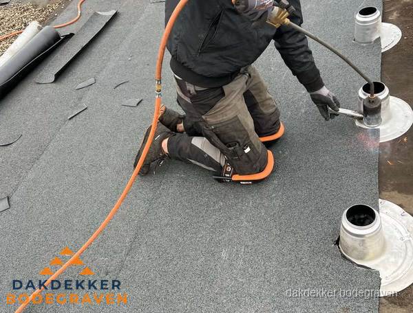 Dakdekker repareert bitumen dakleer bij dakdoorvoer in Bodegraven Dakdekker repareert bitumen dakleer bij dakdoorvoer in Bodegraven