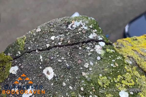Beschadigde en verweerde nokvorst met scheuren en mos in Bodegraven