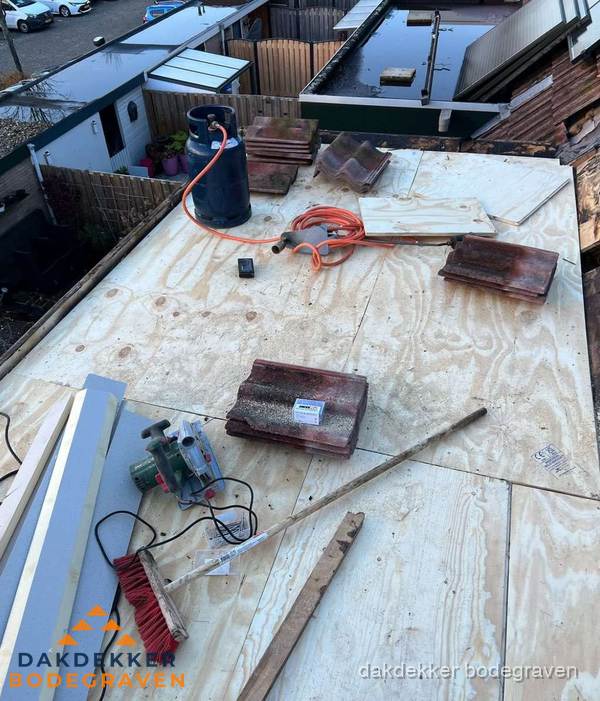 Dakreparatie werkzaamheden op plat dak met gereedschap in Bodegraven