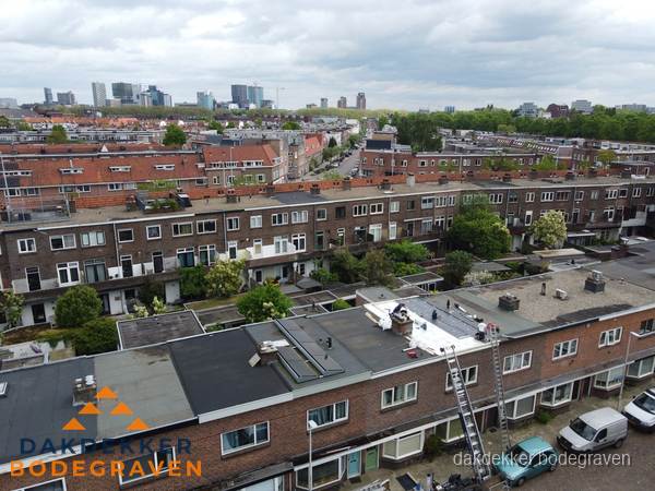 Spoed dakdekker aan het werk op plat dak in woonwijk Bodegraven