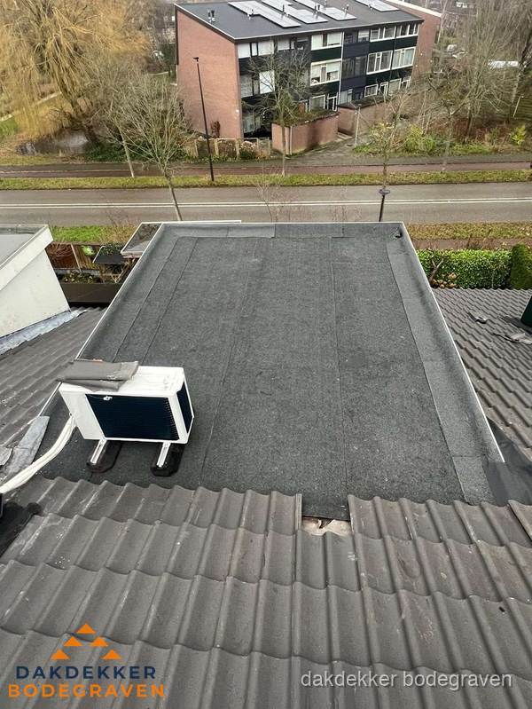Plat dak inspectie met bitumen bedekking naast schuin pannendak in Bodegraven Plat dak inspectie met bitumen bedekking naast schuin pannendak in Bodegraven